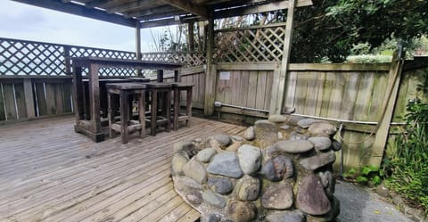 PERGOLA AT THE FRONT OF THE PROPERTY WITH A BAR TABLE, FIREPIT  & OUTDOOR SHOWER