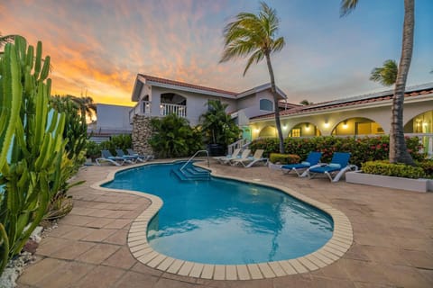 The beautifully landscaped yard surrounds a stunning in-ground pool, making the outdoor area your own private resort.