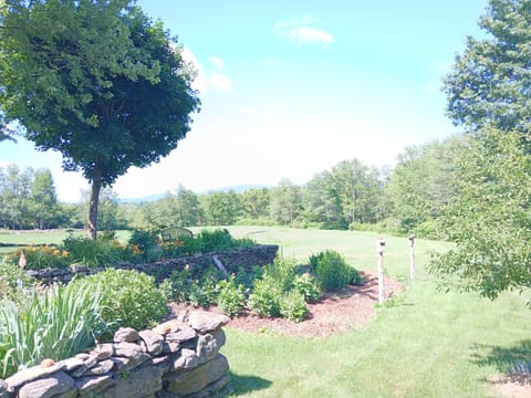 Garden seating area with stone wall and lush landscaping