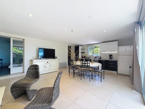 La cuisine offre une efficacité moderne avec ses appareils intégrés. Les chaises ergonomiques sont idéales pour les repas ou la détente, ajoutant une touche contemporaine à l'espace spacieux.