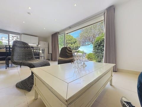 Le salon lumineux dispose d'une grande baie vitrée qui ouvre sur le jardin, idéal pour profiter du paysage en toute saison. Imaginez-vous dans ce cadre apaisant, un verre à la main, savourant la tranquillité.