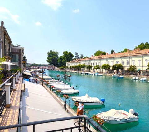Panoramic view of the canal in Peschiera del Garda, with its characteristic historic houses and boats moored along the shore. The apartment is centrally located, just a short walk from restaurants, shops, and romantic walks along the lakefront.