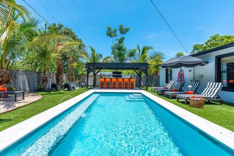 Unwind in a saltwater pool with fountains, sip cocktails under the modern tiki bar with TV 50" ROKU and romantic bistro lights, or lounge by the gas firepit. Surrounded by fresh new palms and coconuts, this backyard oasis feels like a boutique resort.