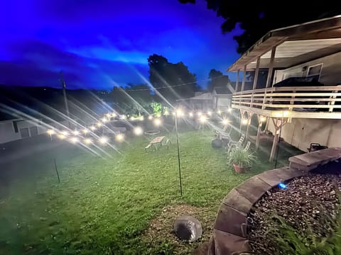 Outdoor lower sitting area with fire pit and lights.