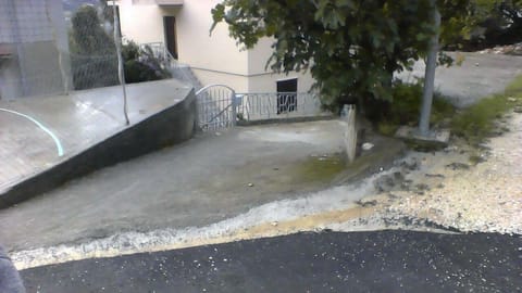 Area that directly surrounds the property. parking place next to the family house behind a lamppost and driveway