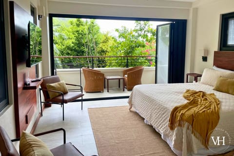 Bedroom with king bed, smart TV, comfy seating, and board games. 