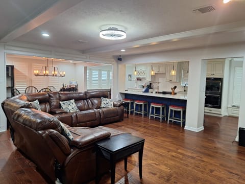 65 inch TV with surround sound, couch with recliners and drink holder.