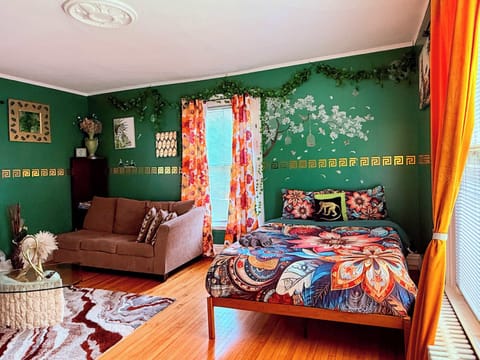 Bright living room with green walls, plush seating, and hardwood floors.