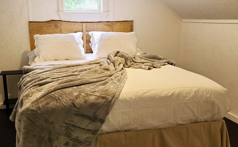 Full Queen Size bed in attic room with milled pine headboard