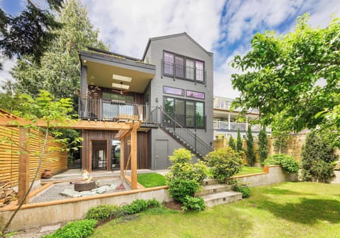 Contemporary gray facade with warm wood accents and lush greenery.