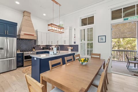 Your spacious open-concept kitchen and dining area invites culinary adventures with modern appliances, stylish navy cabinetry, and warm wood furnishings.
