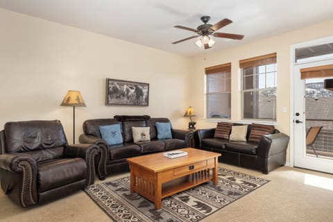 Sink into plush leather sofas in your spacious living room at Ten Mile G-201, where a gentle ceiling fan keeps you cool and natural light streams through large windows.