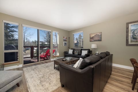 Sink into plush leather sofas while natural light streams through large windows, creating your perfect retreat after mountain adventures.