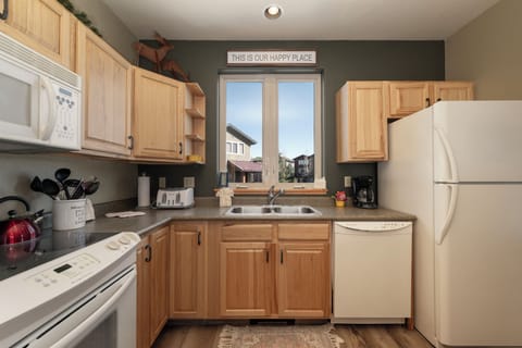 Cook your favorite meals in this fully equipped kitchen with modern appliances and warm wood cabinets.