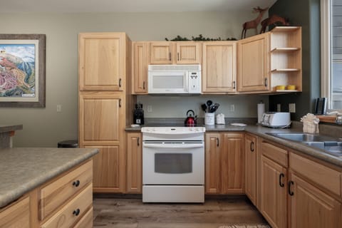 Your fully equipped kitchen awaits with warm wood cabinets, granite counters, and everything needed to create memorable meals during your stay.