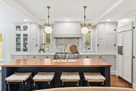 Recently updated state-of-the-art kitchen with a gas range, farm sink, all the dishware and appliances you might need, and seating for four at the kitchen counter.