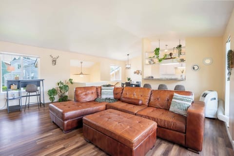 Spacious and inviting living area with natural light and cozy leather sectional