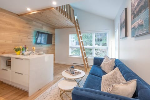 There is a cozy sofa in the living room with stairs to the loft bed.