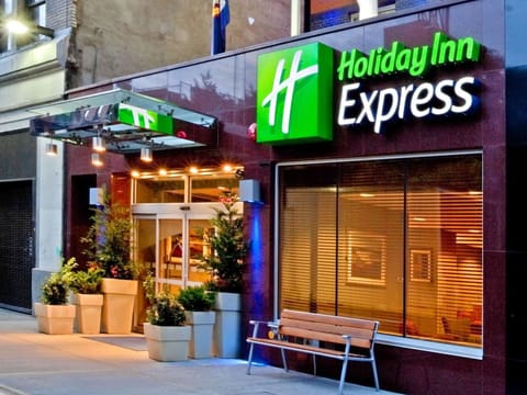 Holiday Inn Express entrance with bright sign and potted plants