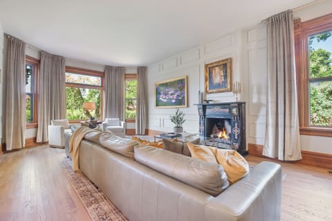 The massive parlor room with casement windows, gas fireplace, huge TV that serves as an art piece when not in use and oversized sofa with sitting area