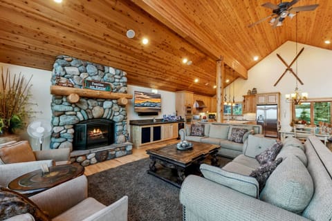 Spacious and open great room with dramatic vaulted ceilings, big views of the lake, river rock gas fireplace and large flat screen SmartTV