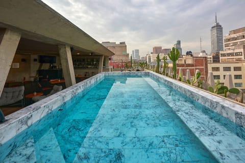 Swim laps in a sleek rooftop pool above the city.