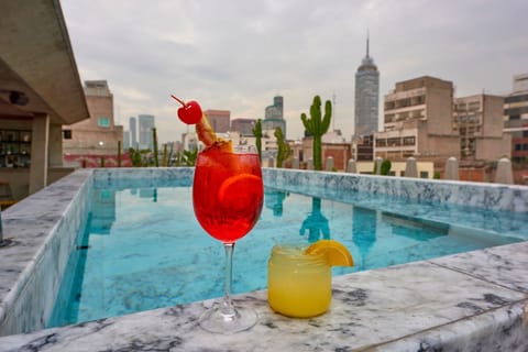 Sip sunset cocktails beside the rooftop pool and skyline.