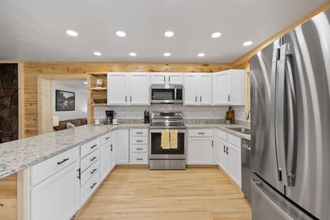 Whip up delicious meals in this fully equipped, bright white kitchen featuring modern appliances and ample counter space!