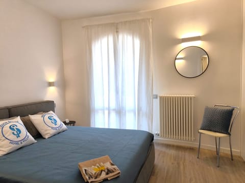 Elegant and bright double room, furnished in a modern style with attention to detail. The neutral tones and natural light from the large windows create a relaxing and comfortable environment, perfect for a stay on Lake Garda.
