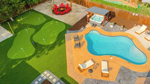 Backyard Oasis: Dive into luxury with a sparkling pool, hot tub, and fun putting greens!