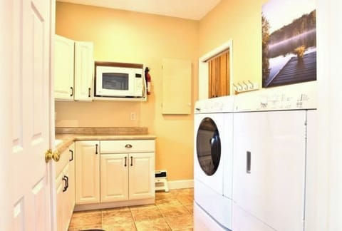 Laundry Room with modern washer and dryer, sink, microwave and lots of cabinets