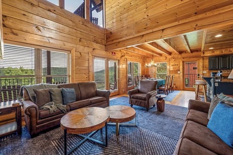 Open concept living room with fireplace, comfortable couches and a smart TV, with a view of the Smoky Mountains. perfect for relaxation and entertainment after a day out at Dollywood, or exploring nature