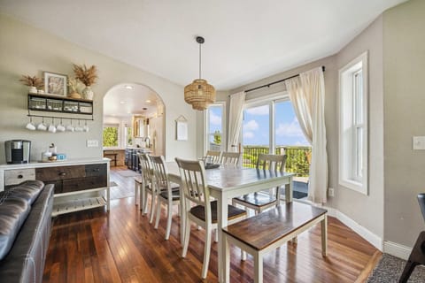 Bright living space framed by large windows and warm natural light