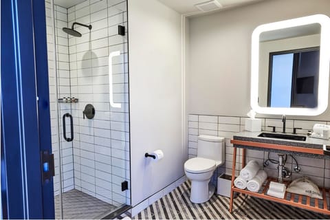 Refresh under a rainfall shower in a bright, spa-like bath.