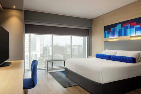 Wake up to sweeping city views from a plush, modern bed.