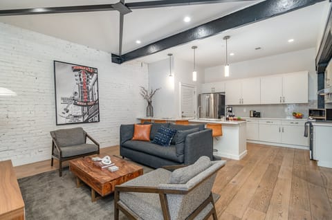 Unit 1: Open-concept living area featuring cozy furnishings, smart TV, and a sleeper sofa.