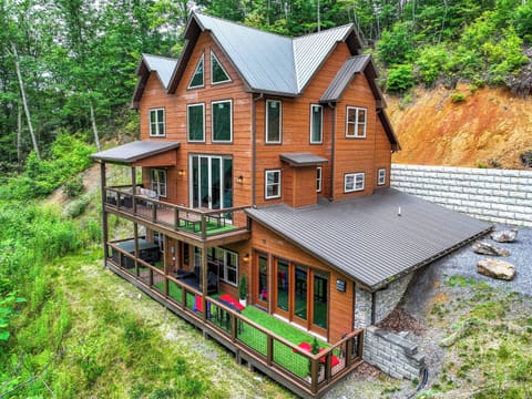 Modern wooden cabin with spacious wraparound decks nestled in a forested hillside.