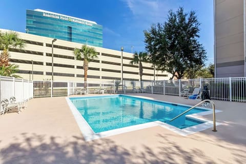 Dive into the sparkling outdoor pool under sunny skies.
