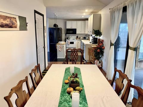 A dining room perfect for setting up a wonderful home cooked meal. Extra seating can be available using chairs from the outside porch area. 