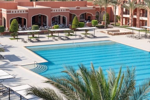 Unwind poolside with shaded seating and calm, clear water.