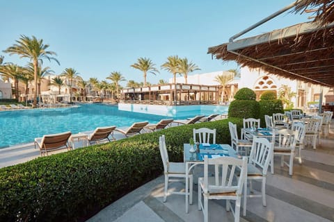 Sip and unwind at shaded tables steps from the refreshing pool.