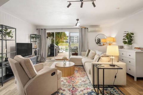 A light-filled living area with plush seating and a smart TV creates the perfect space to unwind, whether enjoying a movie night or taking in glimpses of the lake through wide glass doors.