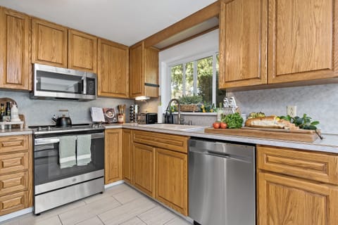 Bright, fully-equipped kitchen with stainless steel appliances and garden views.