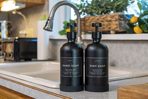 Premium hand and dish soap in sleek matte black dispensers for a modern touch.