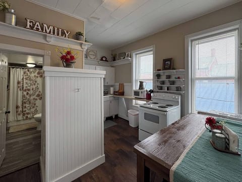 Open concept kitchen and dining area with a rustic wooden table and chairs.