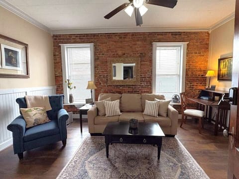 Cozy living room with exposed brick, comfortable seating, and natural light.