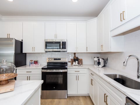 Fully stocked kitchen with stainless steel appliances and island seating