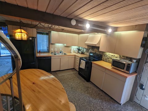 KITCHEN:  The kitchen with all the basic cooking appliances including a dishwasher and coffeemaker along with a wooden table and stools