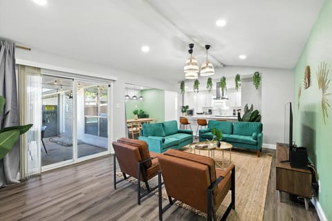 With touches of decorative greenery and plenty of seating, this living room is the perfect place to unwind after a long day and enjoy time with your companions.