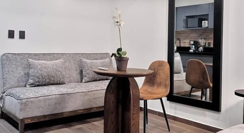 Bright living area w/ cozy sofa, small table & glass doors bringing in soft natural light